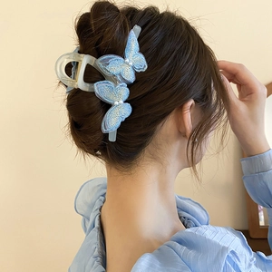 Detail of blue embroidered butterfly hair claw clip with pearls on model back view