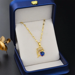 Golden dolphin necklace with blue crystal cube and zircon details in a jewelry box