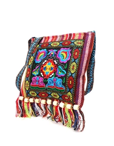 Detail of bohemian embroidery and colorful fringe with beads on a black crossbody bag
