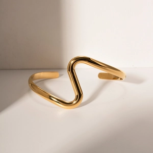 Minimalist 18K gold plated stainless steel wave bangle with a polished geometric design