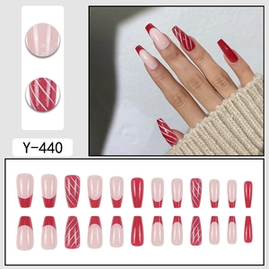 Press-on ballerina nails with red French tips and festive snowflake patterns