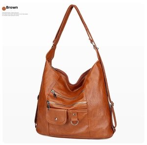 Detailed view of brown soft leather shoulder bag featuring multiple functional zippers