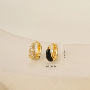 Detail view of 1.4cm gold earrings with clear zircon stones and black enamel coating