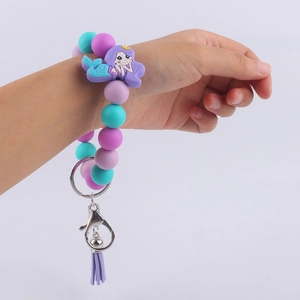 Cartoon mermaid silicone beaded wristlet keychain with purple tassel on child wrist