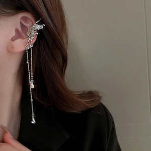 Dettaglio di earcuff a farfalla argento con lunghe nappe a catena e pietre di zircone