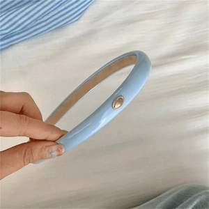 Nahaufnahme eines blauen PU-Leder-Stirnbands mit metallener HIMES-Schnalle in der Hand