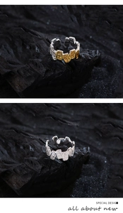 Close-up of 925 sterling silver rings with square texture on dark volcanic rock