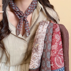Detailed view of women silk scarf necklace with vintage paisley print and textile texture