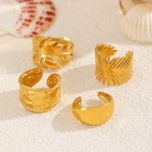 Detailed view of four adjustable gold-plated rings with leaf, hammered, and smooth textures