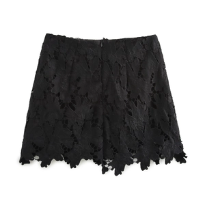 Dettaglio gonna in pizzo nero con intricati motivi floreali e bordo smerlato rifinito