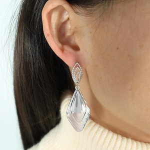 Elegant geometric silver drop earrings with textured leaf design and glossy metal finish
