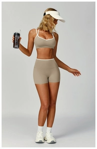 Women's yoga set detail featuring oatmeal sports bra and shorts with white contrast trim