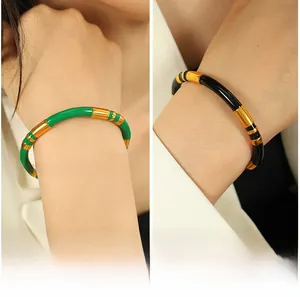 Close-up of bamboo-style stainless steel bracelets with green and black enamel details