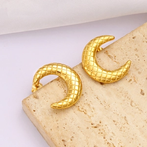 Close-up of golden crescent moon earrings with diamond lattice pattern on stone base
