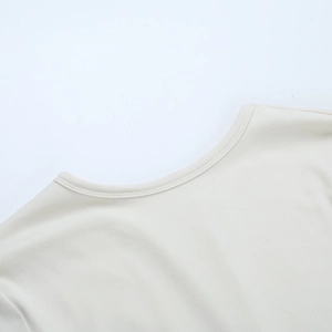 Detail of crew neckline stitching and texture on a light beige knitted dress