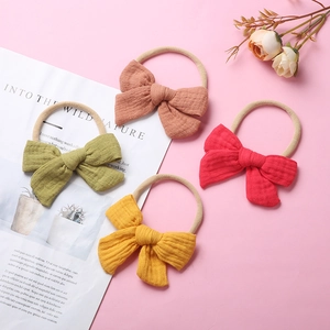 Set of 4 soft cotton muslin baby headbands with bows in earthy tones on nylon bands