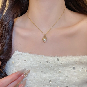 Nahaufnahme der 18k vergoldeten Halskette mit Zirkonia und Perlenanhänger am Model