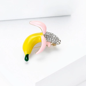 Macro detail of cartoon banana brooch with sparkling crystals and yellow enamel finish