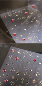 Vista macro di adesivi per unghie 3D con stelle, lune e motivi di pianeti rossi