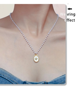 Effetto indossato di una collana di perle con ciondolo ovale dorato a stella su una modella