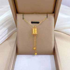 Minimalist gold titanium steel necklace with cylindrical pendant in beige jewelry box