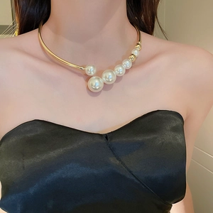 Detail of elegant gold choker necklace with graduated pearls worn on neck