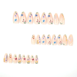 Floral almond press-on nails with colorful flower patterns on a soft pink base