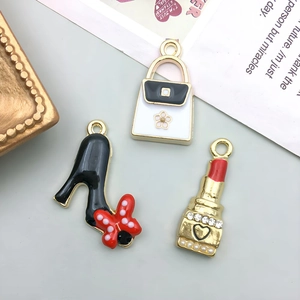 Macro view of colorful enamel bag charms with pearls and rhinestones on a decorative card