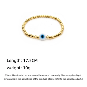 Elastic gold bead bracelet featuring a classic blue evil eye charm for women