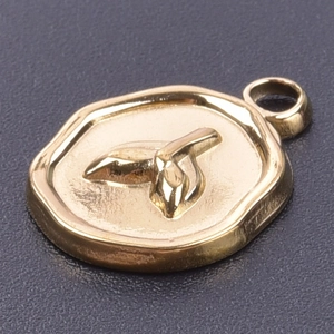 Macro detail of a 18k gold plated fishtail pendant with leaf relief design in octagon shape