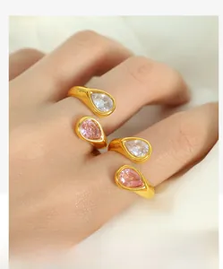 Detail of gold open rings with pear-cut pink and clear cubic zirconia on a hand
