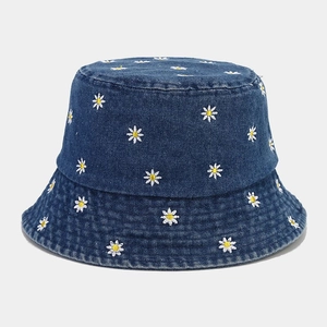 Dettaglio del ricamo a margherita sul tessuto denim blu scuro del cappello alla pescatora