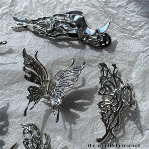 Macro shot of silver liquid metal butterfly hair claw clip with glossy surface finish