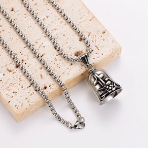 Vintage stainless steel motorcycle bell pendant with cross relief on stone pedestal