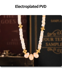 Macro shot of baroque freshwater pearls and shell beads on an 18k gold-plated necklace