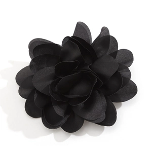 Detailed macro view of black fabric rose brooch with layered flower petals for hair or clothing