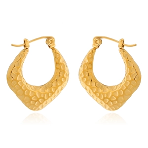 Vue détaillée de boucles d'oreilles croissant dorées avec une texture en métal martelé