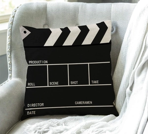 Detailed view of movie clapperboard style pillow on armchair with printed production fields
