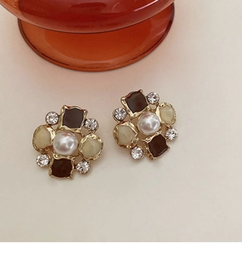 Macro detail of vintage floral earrings with pearl, brown enamel, and sparkling crystals