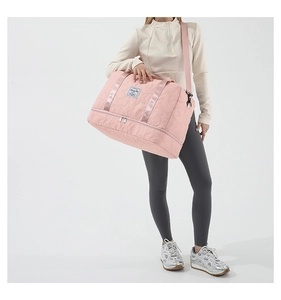 Detailed view of pink quilted star fitness bag featuring double handles and a shoulder strap