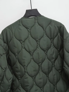 Detail of dark green quilted jacket featuring classic wavy onion stitching pattern