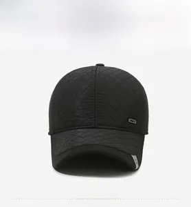 Detailed view of black quilted baseball cap with diamond stitching and metal accent