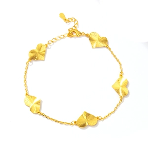 Detailed close-up of gold heart charm bracelet with lobster clasp and extension chain