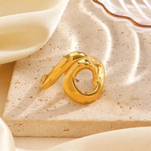 Bague ouverte ajourée irrégulière en finition dorée liquide sur socle en pierre