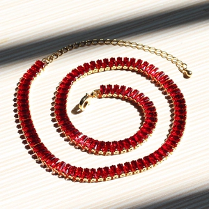 Detail of gold necklace with rectangular red zircon crystals and adjustable chain