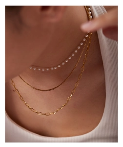 Close-up of triple-layered necklace with pearls and gold chains worn by a model