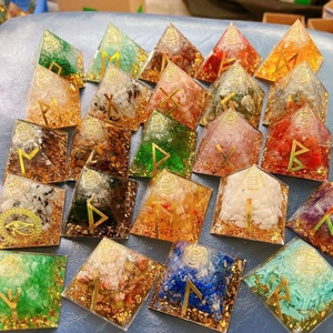 Macro shot of assorted crystal resin pyramids with gold foil and rune symbols