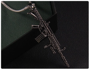 Macro shot of a silver stainless steel assault rifle pendant with detailed gun textures
