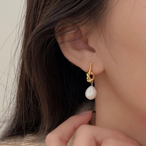 Elegant 925 sterling silver knot earrings with white baroque pearls on a model