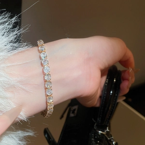 Close-up of a sparkling gold tennis bracelet with cubic zirconia on a woman's wrist